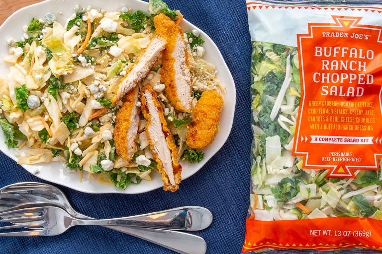 Platter of Trader Joe's Buffalo Ranch Salad topped with blue cheese &amp; sliced breaded chicken breasts